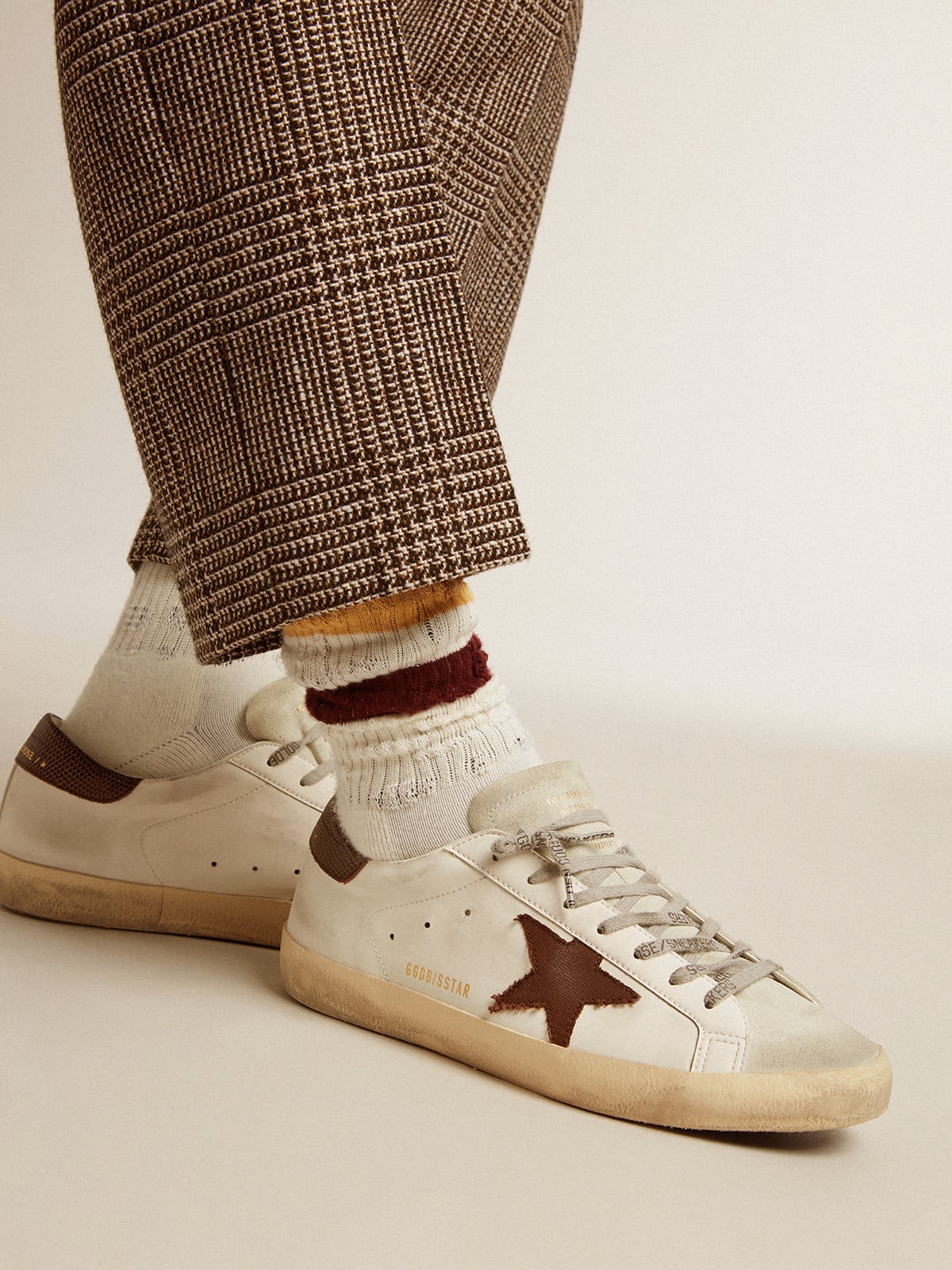 Worn white with distressed details and two-tone mustard and burgundy stripes| Golden Goose