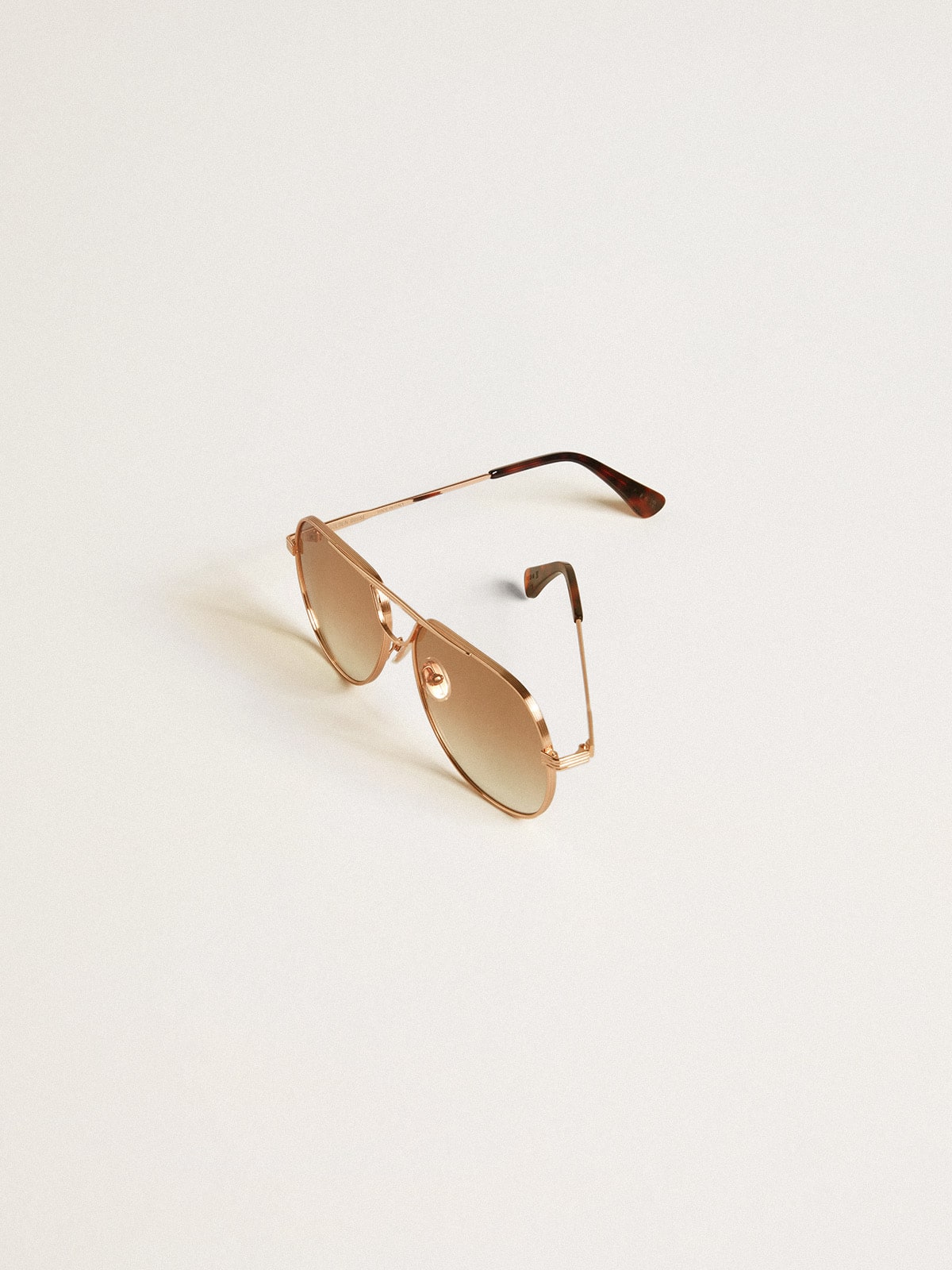 Aviator style sunglasses with rose-gold frame and honey-colored lenses| Golden Goose